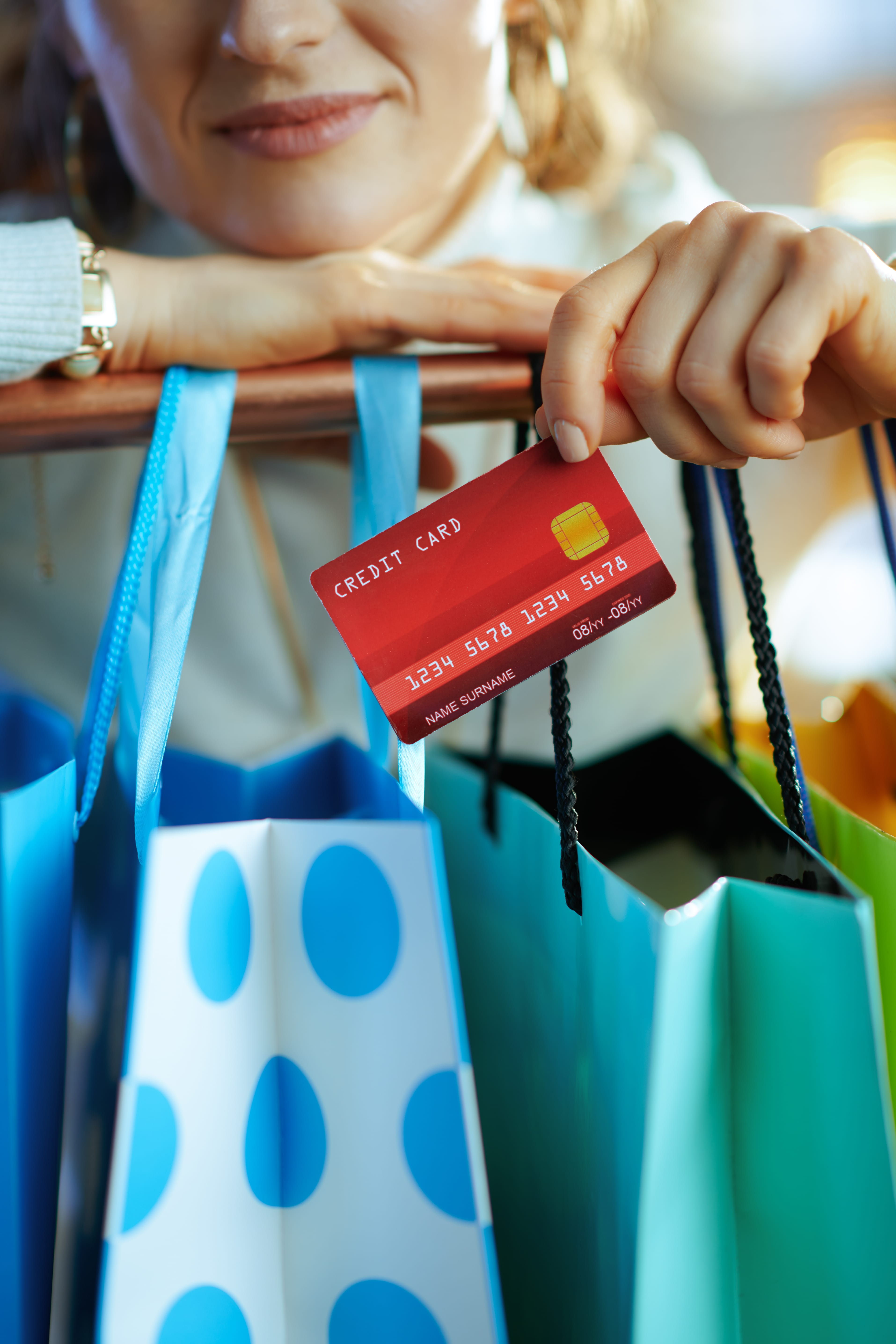 image of woman holding credit card and shopping bags